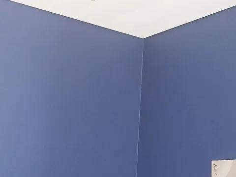 Freshly painted interior walls meeting at a corner in blue-grey