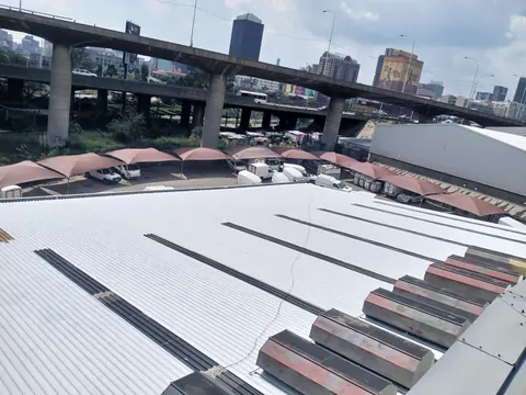 Finished white factory roof with the city skyline in the distance