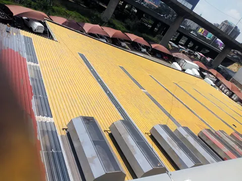Corrugated factory roof with gold primer applied over older sheeting