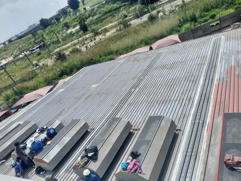 MP crew preparing a weathered corrugated roof before coating